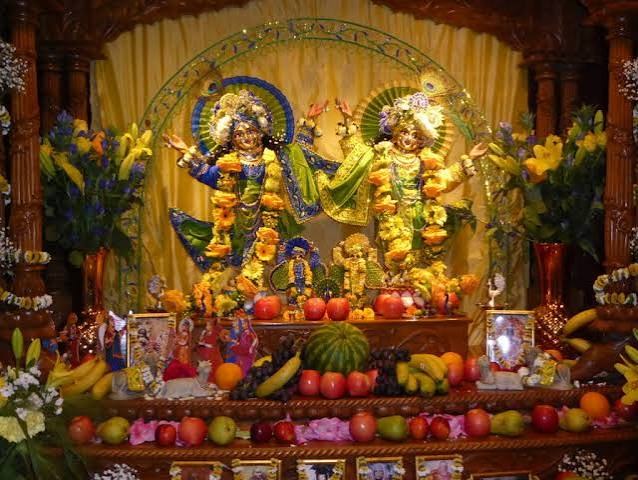 Sri Sri Gaura-Nitai on the altar, with offerings of fruit and flowers